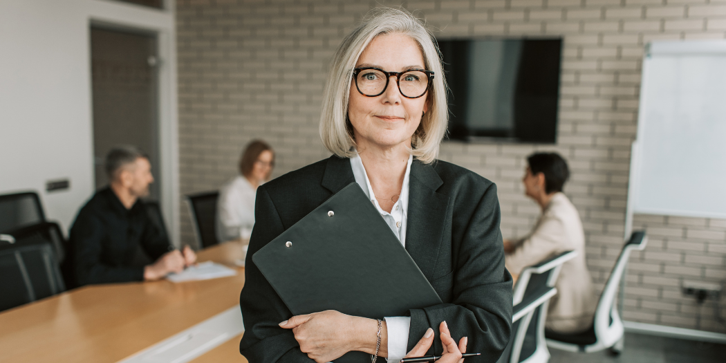Female financial advisor holding a folder in a professional office setting during a client meeting